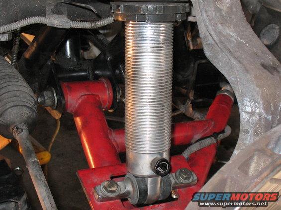 Red suspension arm and silver coilover shock absorber with adjustment knob