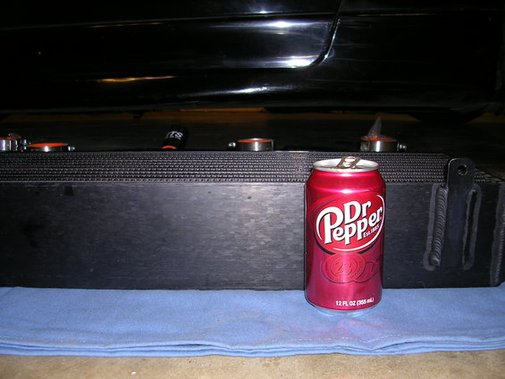 Black car undercarriage with a large black intercooler and a red Dr Pepper can