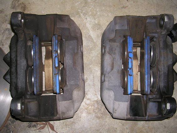 Pair of brake calipers with blue brake pads