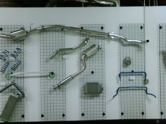 Exhaust system parts displayed on a grid wall