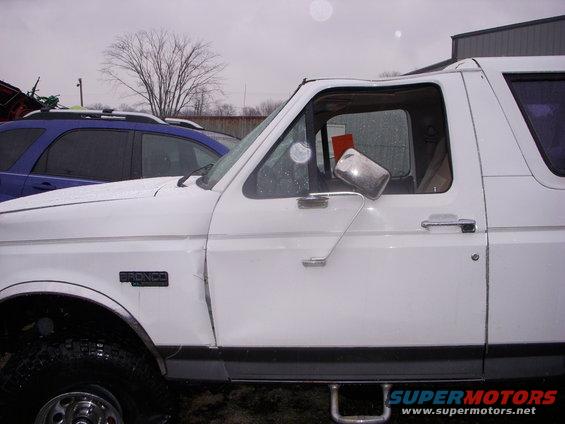 White 1995 Ford Bronco side view with a black Bronco badge on the fender