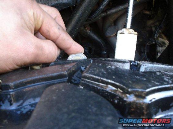 Hand holding coin near engine component