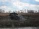 1990 Ford Bronco - A mud-covered pickup truck is stuck in a muddy field, with a person observing the scene.