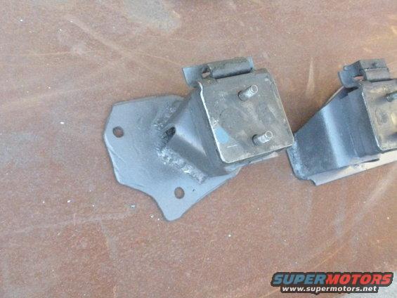 Two metal engine mounts with rubber dampening, one in focus
