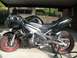 2008 Kawasaki Ninja R - A black Kawasaki Ninja motorcycle with flame decals and red rims is parked under a carport.