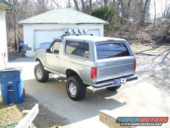 Silver 1994 Ford Bronco with roof lights and lifted suspension parked in a driveway