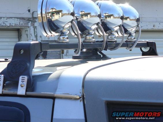 Roof rack with four chrome spotlights on a silver SUV