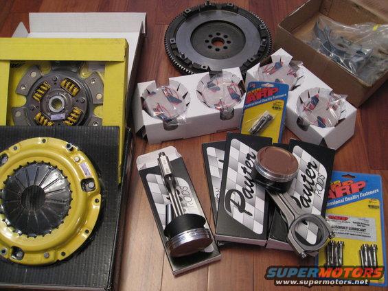 Collection of engine parts including a flywheel, clutch, pistons, connecting rods, and ARP fasteners