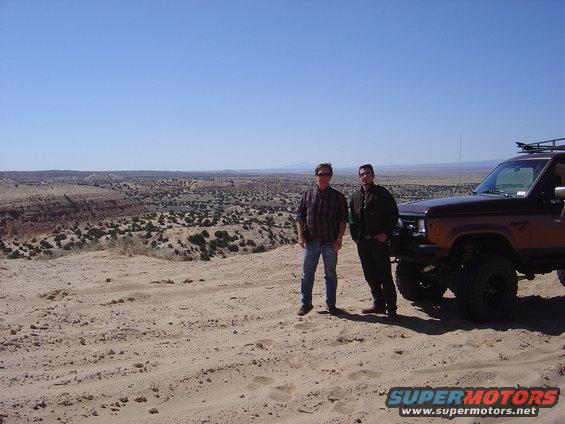 1986 Ford Bronco II, 3q-front view, brown with roof rack, parked in desert with two men