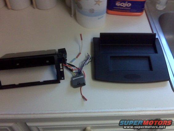 Car stereo mounting kit and wiring harness on a countertop