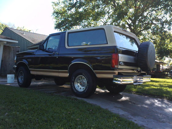 Black and tan 1994 Ford Bronco rear quarter view with spare tire on back