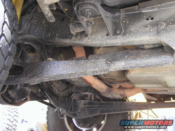 Underside view of vehicle chassis, showing suspension components and exhaust system. Watermark 'SUPERMOTORS.NET' visible