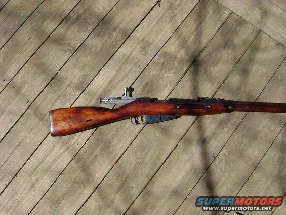 Wooden stock and metal receiver of a Mosin-Nagant rifle on a wooden deck