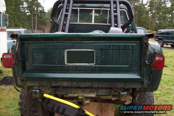 Dark green pickup truck rear with roll bar and trailer hitch