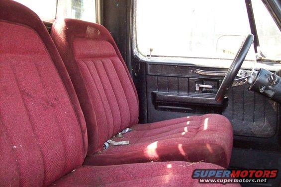 1976 Chevrolet C/K Pickup interior with red cloth bench seat and black door panel