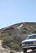 1996 Ford Bronco - Several SUVs navigate a dusty, off-road trail on a sunny day.