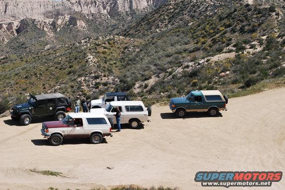 1996 Ford Bronco parked on dirt road with other vehicles
