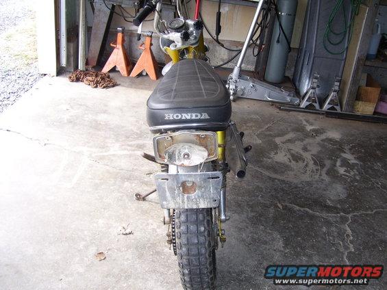 Rear view of a Honda motorcycle seat and taillight assembly. Supermotors.net logo visible