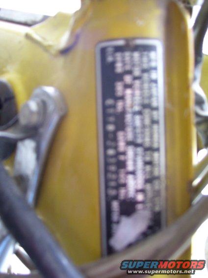 Yellow motorcycle frame with a black data plate showing text