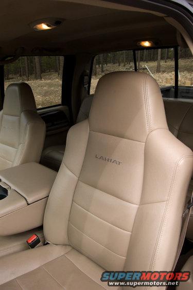 Tan leather seats with 'Lariat' stitched on the driver's seat. Interior view of a truck cab
