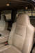 2003 Ford F-350 - The interior of a truck cab shows tan leather seats with 'Lariat' stitching.