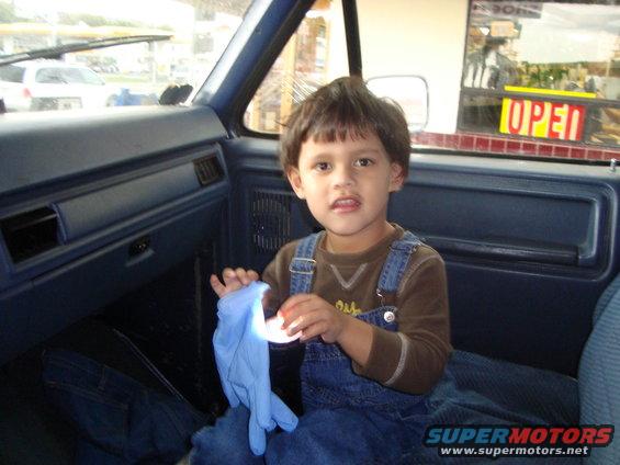 Interior of a 1986 Ford Bronco with a child holding a blue glove