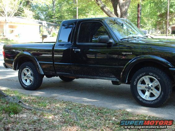 Black Ford Ranger pickup truck, side view. Has "Ranger" badge on fender