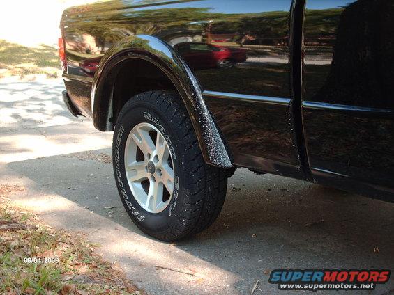 Black pickup truck rear wheel well with silver alloy wheel and Pathfinder tire. Date stamp 06/04/2009