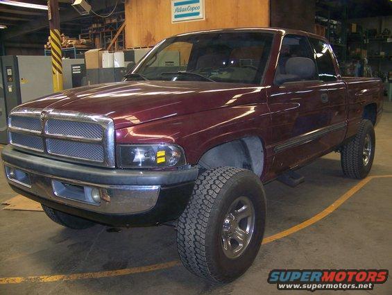 Maroon pickup truck, 3/4 front view, in a garage. The vehicle has a chrome grille and black bumper