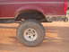 1992 Ford Bronco - The rear side view of a red 1992 Ford Bronco shows its large tire and fender.