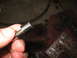 1995 Ford C-350 (Centurion Conversions) - A metal transmission part is held by fingers, with blurred transmission components visible in the background.