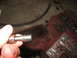 1995 Ford C-350 (Centurion Conversions) - Close-up of a transmission part being held, with a valve body visible in the background.