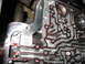 1995 Ford C-350 (Centurion Conversions) - Automatic transmission valve body with red fluid visible in the channels.