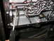 1995 Ford C-350 (Centurion Conversions) - Close-up view of a transmission pan interior, showing internal components and a screwdriver. Part numbers are visible on the casing.