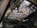 1995 Ford C-350 (Centurion Conversions) - Close-up view of a vehicle's transmission pan, showing the bolts and fluid seepage.