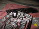 1995 Ford C-350 (Centurion Conversions) - Disassembled transmission valve body with filter and internal passages visible, red fluid present.