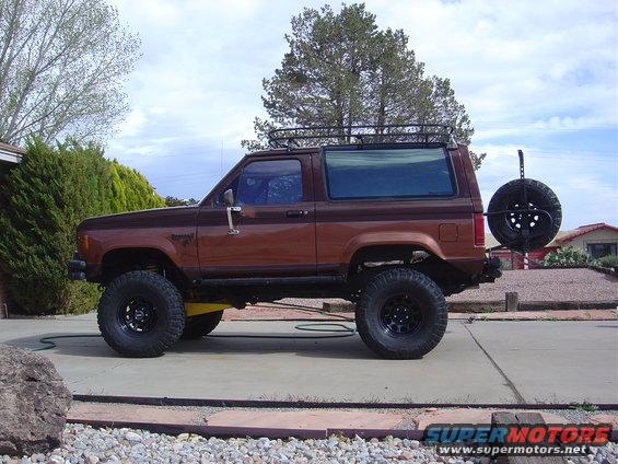 1986 Ford Bronco II side view, brown, with roof rack and rear spare tire