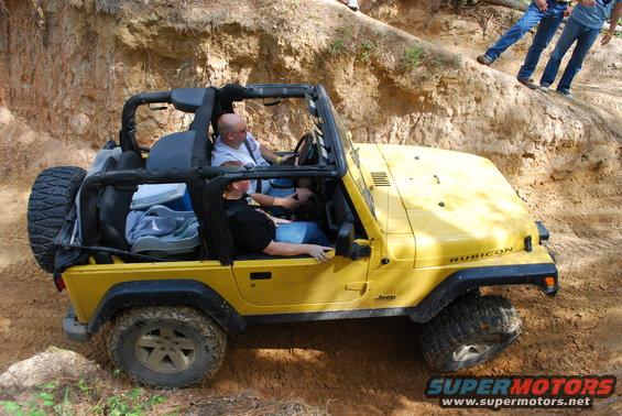 Yellow 2008 Jeep Wrangler Rubicon off-roading on a dirt trail