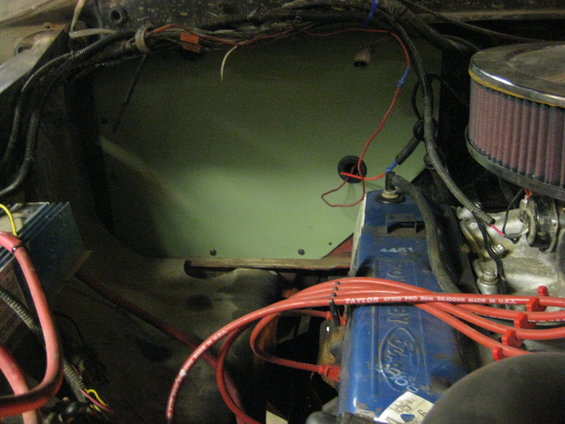 Engine bay with blue Ford valve covers, red spark plug wires, and air filter. Green firewall panel visible