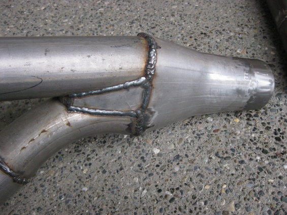 Close-up of welded exhaust pipe section with some markings on the end