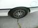 1989 Ford Probe - Close-up of a white car's rear wheel and part of the body, showing the fender and gas cap door.