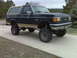 1990 Ford Bronco - This lifted Ford Bronco features a two-tone paint scheme and off-road tires.