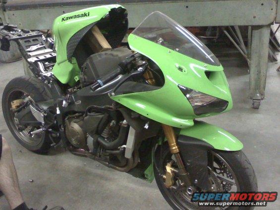 Green Kawasaki Ninja R motorcycle, appears to be undergoing some work. The fairings are on, but the rear section is exposed