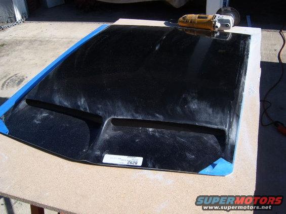 Black car hood with two vents, taped edges, and a label with '2628'