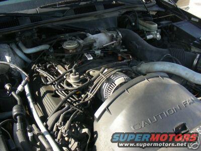 Engine bay with "CAUTION FAN" cover and "SUPERMOTORS" watermark