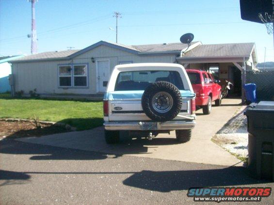 1982 Ford Bronco rear view, parked in driveway next to a red SUV