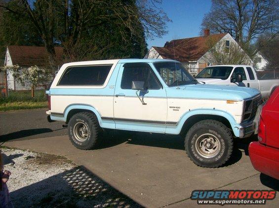Two-tone blue and white Ford Bronco parked in a driveway