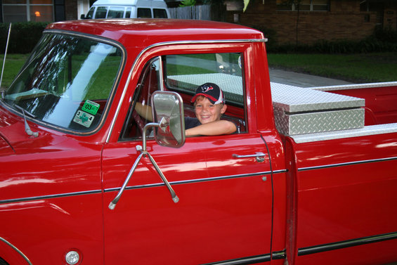 Boy in a red pickup truck, diamond plate toolbox in bed