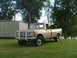1975 International Scout II - This International pickup truck is parked on a grassy lawn next to a shed with trees and water in the background.