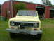 1975 International Scout II - A yellow 1975 International Scout II is parked outside a red barn with a winch mounted on its front bumper.